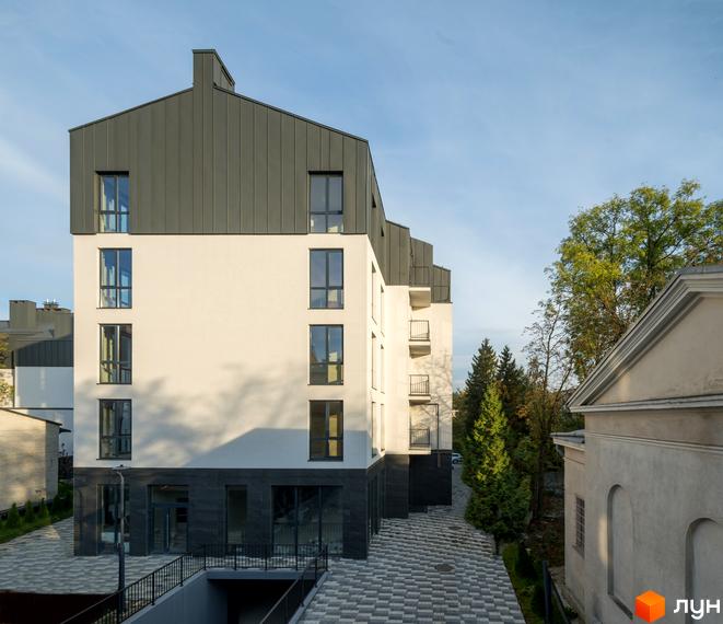 Сучасний житловий комплекс Globus Elite з білою фасадною частиною та сірим дахом. Прибудинкова територія з бруківкою та зеленими насадженнями.