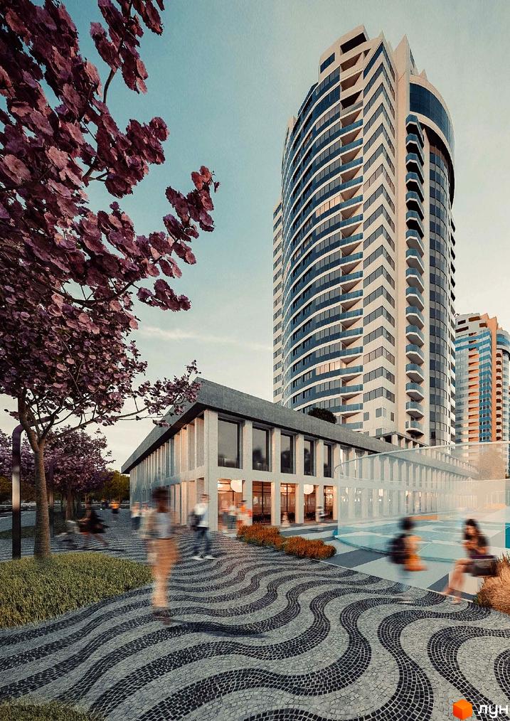 Висотна будівля житлового комплексу The First House з панорамними вікнами та прибудинковою територією з бруківкою та деревами.