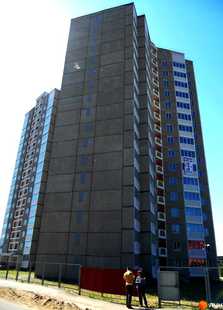 Житловий комплекс на вул. Першого Травня, 12/1. Високий будинок з великими вікнами та прибудинковою територією.