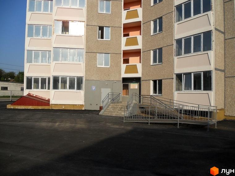 Зовнішній вигляд будинку на вул. Першого Травня, 12/1, з прибудинковою територією та пандусом для зручності.