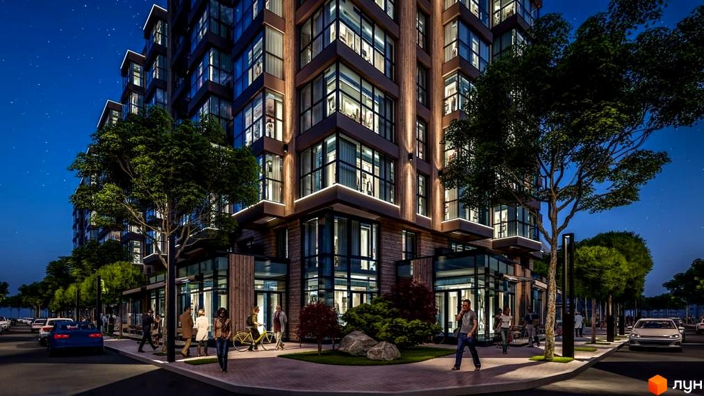 Новобудова ЖК PARKOVIY з панорамними вікнами та підсвіткою ввечері. Навколо будинку зелені дерева та пішохідна зона з людьми.