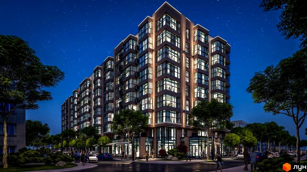 Житловий комплекс PARKOVIY вночі з підсвіченими вікнами та фасадом, оточений деревами та міською інфраструктурою.