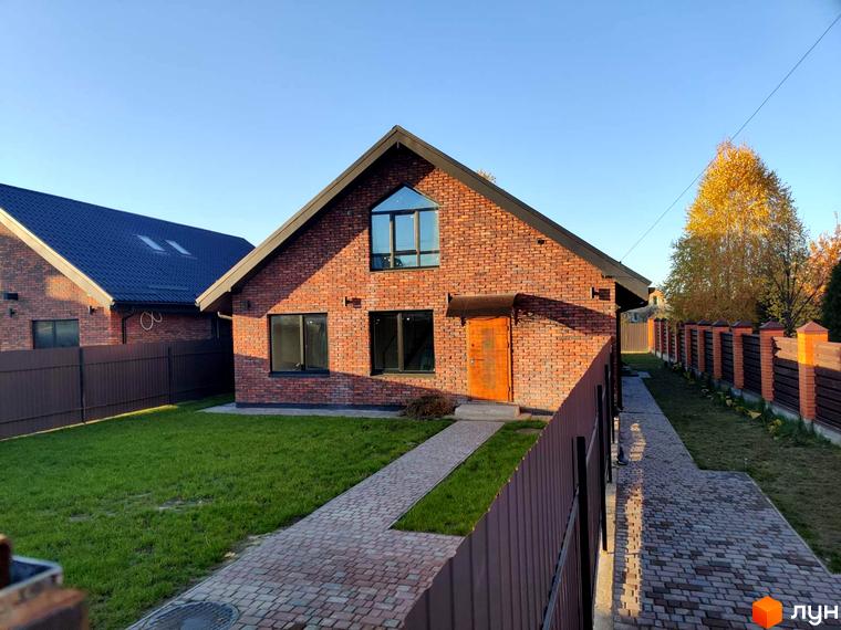 Котеджне містечко Одноповерховий Київ - Дніпро. Цегляний будинок з великими вікнами та дерев'яними дверима, огороджений парканом, з доглянутим газоном та бруківкою.