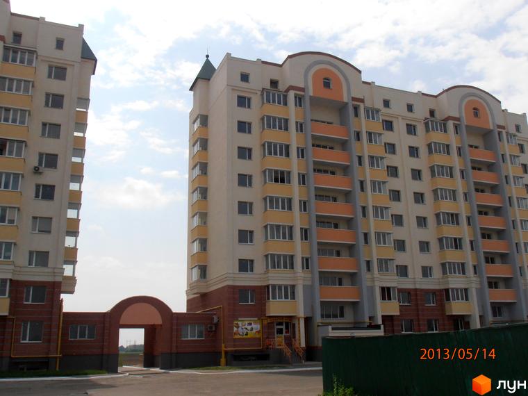 Житловий комплекс Юність з фасадом, що складається з кількох секцій, та прибудинковою територією.