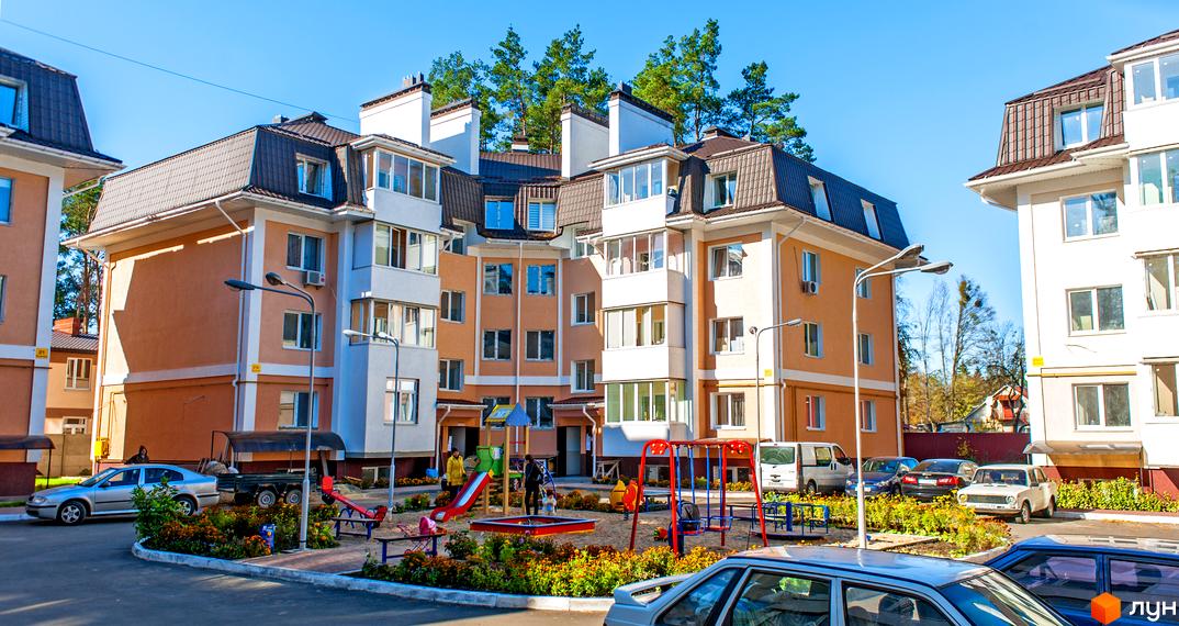 Зовнішній вигляд житлового комплексу Матросова з прибудинковою територією та дитячим майданчиком.