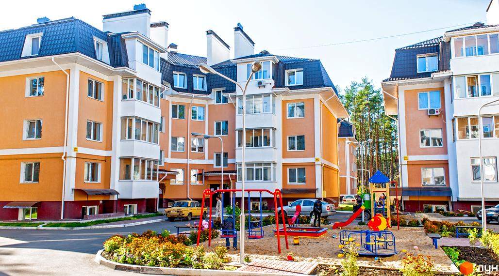 Зовнішній вигляд житлового комплексу Матросова з яскравими фасадами та прибудинковою територією з дитячим майданчиком.