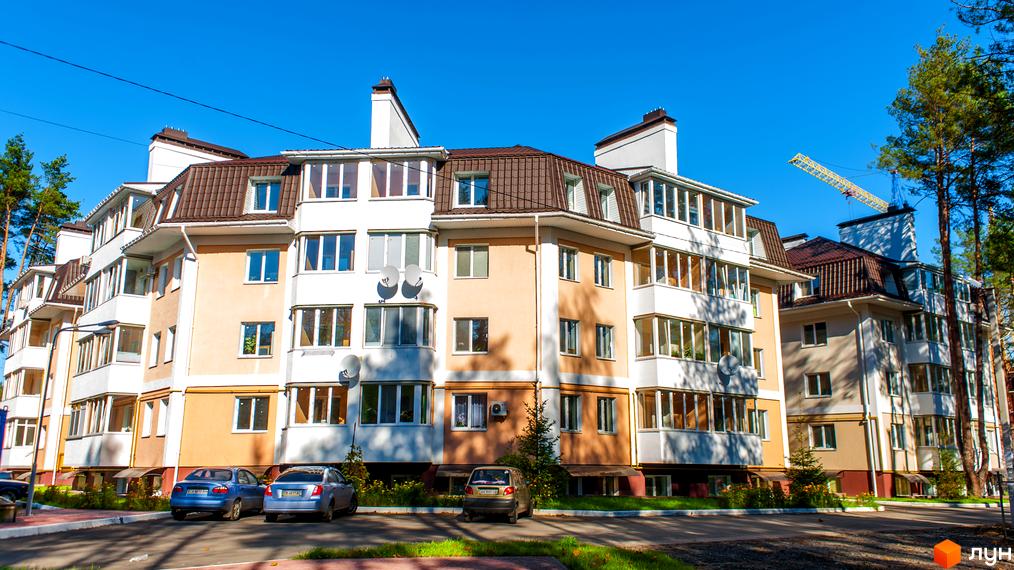 Зовнішній вигляд житлового комплексу Матросова з парковкою та зеленими насадженнями на прибудинковій території.