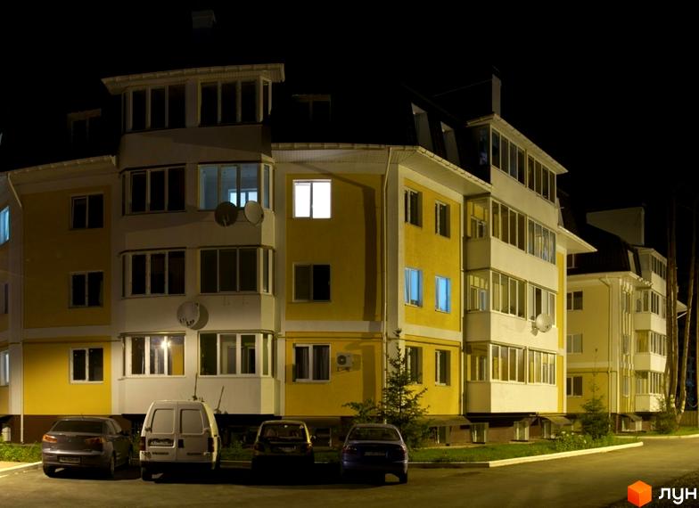 Житловий комплекс Матросова з жовтою фасадною обробкою та великими вікнами. Прибудинкова територія з автомобілями та зеленими насадженнями.