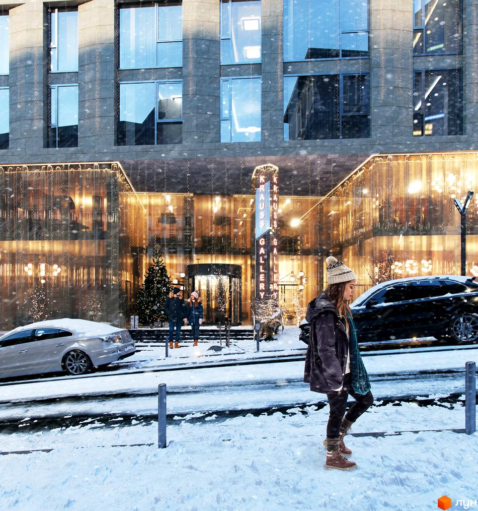 Фасад житлового комплексу Krauss Gallery з великими вікнами та кам'яним облицюванням. Будівля прикрашена святковою ілюмінацією, навколо сніг та пішоходи.