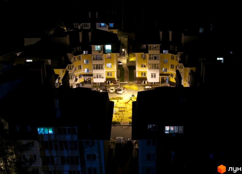 Житловий комплекс Матросова вночі, з жовтими будинками та освітленою прибудинковою територією.