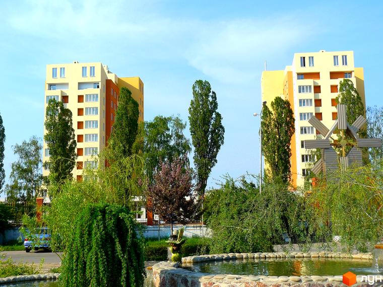 Житловий комплекс Новосельцево з двома багатоповерховими будинками та зеленими насадженнями на прибудинковій території.