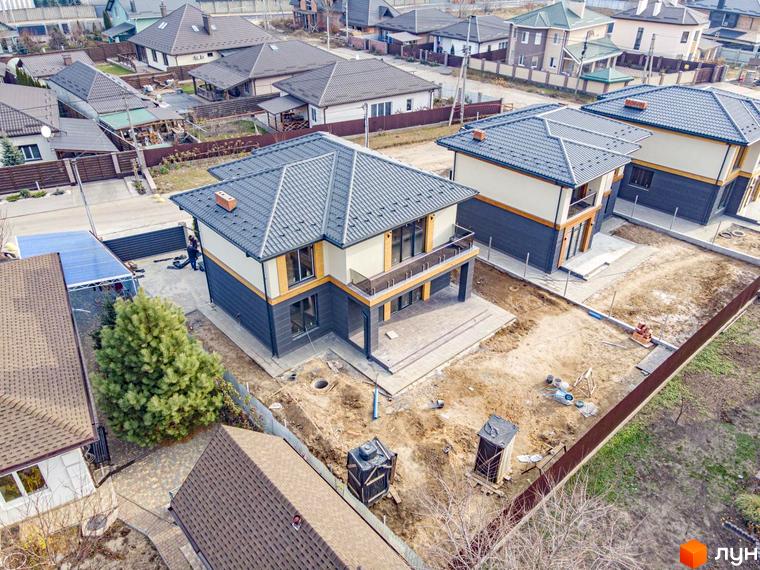 Котеджне містечко Family Villas: будинки з сірими дахами, світлими верхніми та темними нижніми фасадами. Прибудинкова територія на етапі облаштування.