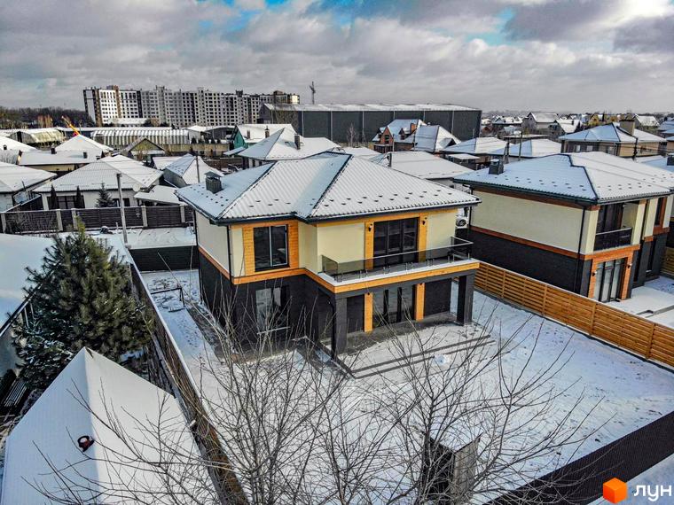 Котеджне містечко Family Villas: двоповерхові будинки з світлими фасадами та дерев'яними елементами, вкриті снігом. Територія також засніжена.