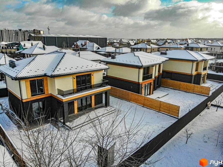 Котеджне містечко Family Villas: двоповерхові будинки з сірими дахами та світлими фасадами, прибудинкова територія вкрита снігом.