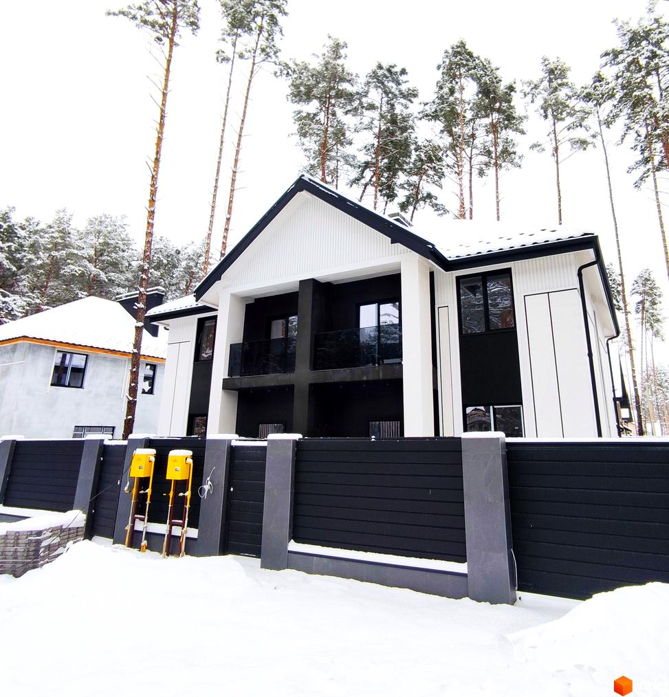 Дуплекси Toscana Home у зимовому ландшафті з сучасним фасадом та огородженою територією. Зовнішній вигляд будинку вражає своєю архітектурою.