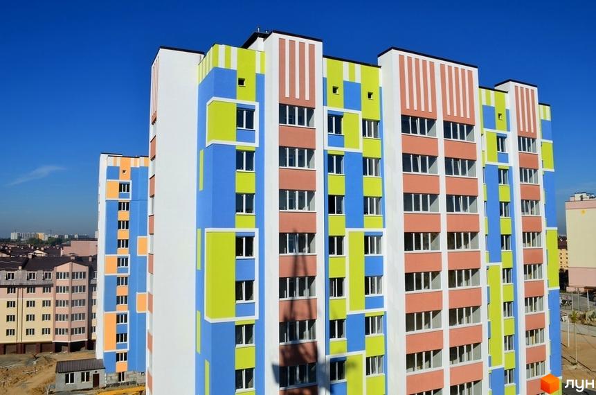 Житловий комплекс Софіївська Слобідка з яскравою фасадною обробкою. На передньому плані вид на прибудинкову територію.