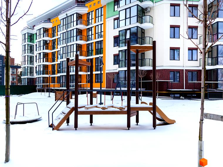 Житловий комплекс Лісова казка 2 з яскравим фасадом та дитячим майданчиком, засніженим двором. Сучасна архітектура новобудови.