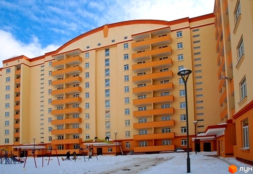 Житловий комплекс Яблуневий з жовто-оранжевим фасадом та балконами. Прибудинкова територія з дитячим майданчиком та освітленням.