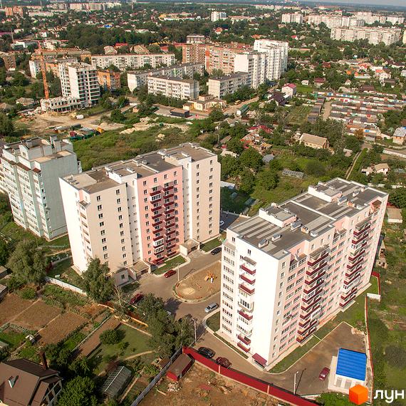 Зовнішній вигляд житлового комплексу Нове Життя з багатоповерховими будинками та прибудинковою територією. Фото новобудови.
