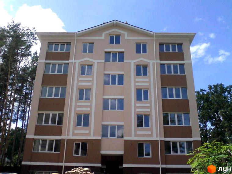 Фасад житлового комплексу Квартал на „Київській“ бежевого та коричневого кольорів з білими вікнами. Поруч високі дерева.