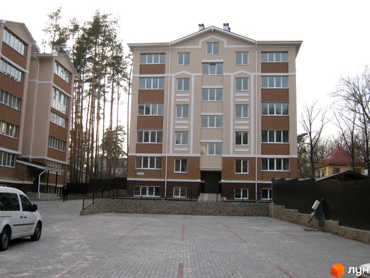 Житловий комплекс Квартал на „Київській“ з фасадом у світлих тонах та прибудинковою територією з бруківкою.