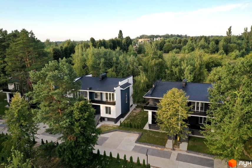 Котеджне містечко Терещенські Озера: двоповерхові будинки з чорними дахами та біло-синіми фасадами, оточені зеленню та доглянутою територією з доріжками.