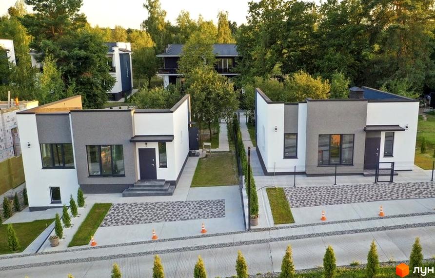 Котеджне містечко КМ Терещенські Озера: фасади будинків білого та сірого кольору, доріжки з бруківки та зелені насадження.