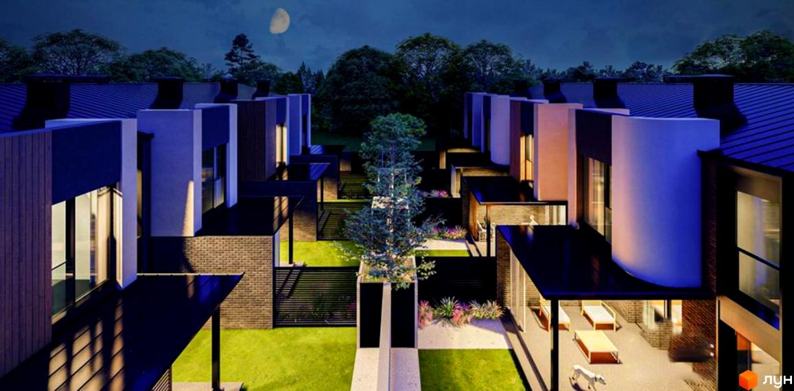 Котеджне містечко КМ ВДОМА вночі. Сучасна архітектура будинків та доглянута прибудинкова територія з газоном та деревами.