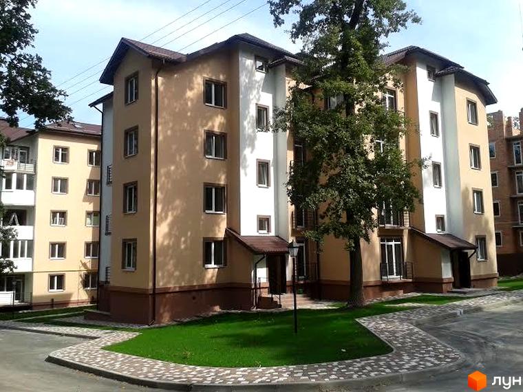 Житловий комплекс Джерело з фасадом світлих кольорів та прибудинковою територією з зеленими насадженнями.