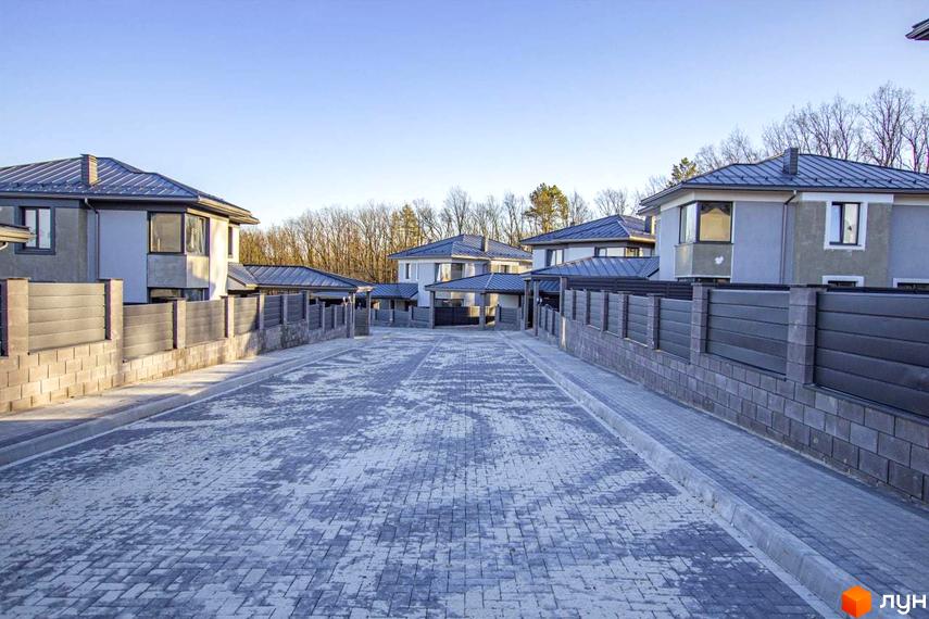Котеджне містечко КМ NOVYI SVIT: фасади будинків з сірим дахом та сірими парканами, вимощені сірою плиткою вулиці.