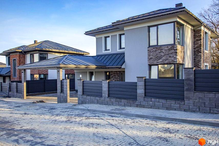 Котеджне містечко КМ NOVYI SVIT. Зовнішній вигляд двоповерхових будинків з сірою штукатуркою, цегляними вставками та металевим дахом. Прибудинкова територія з кам'яним парканом.