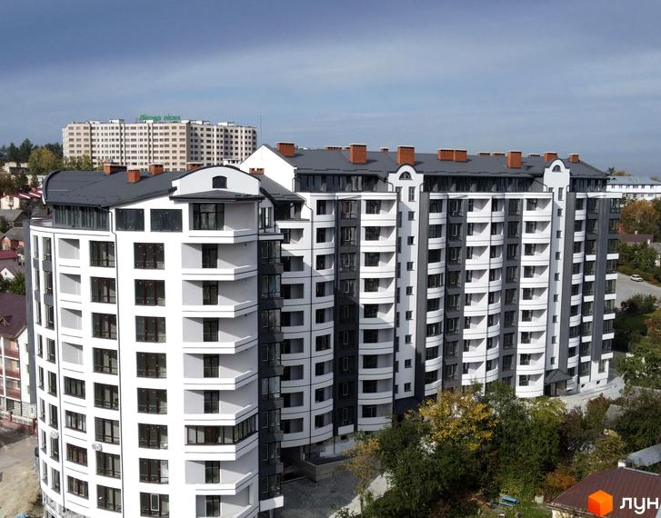 Зображення фасаду Житлового комплексу Трускавецька Фортеця. Багатоповерховий будинок з біло-сірим оздобленням та великою кількістю вікон.