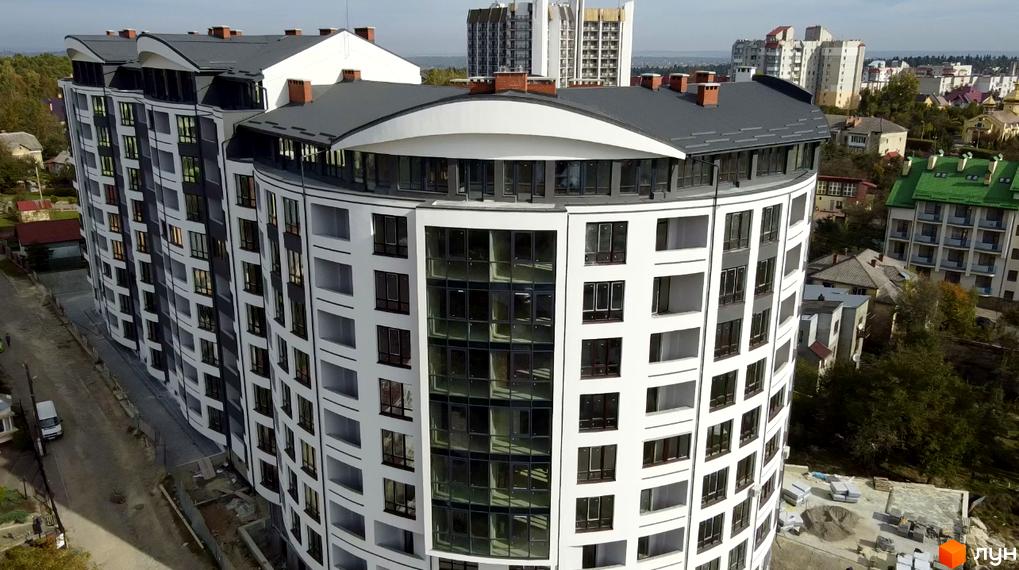 Зображення Житлового комплексу Трускавецька Фортеця. Багатоповерховий будинок з великими вікнами та сірим дахом.