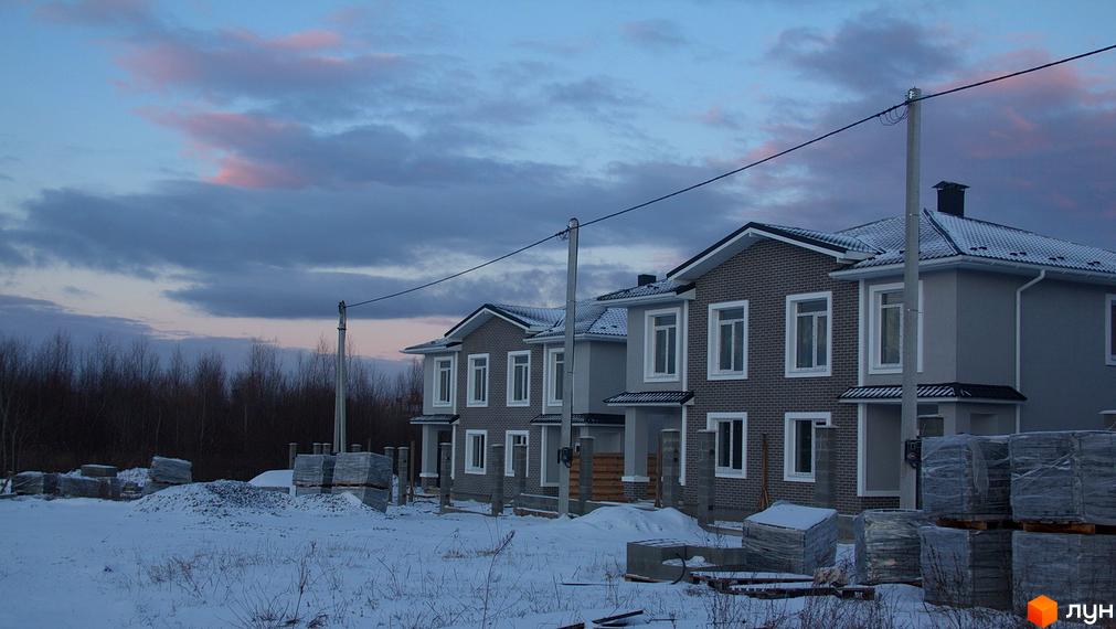 Новобудова на вулиці Василя Стуса. Навколо будинку розташовані будівельні матеріали та дерева.