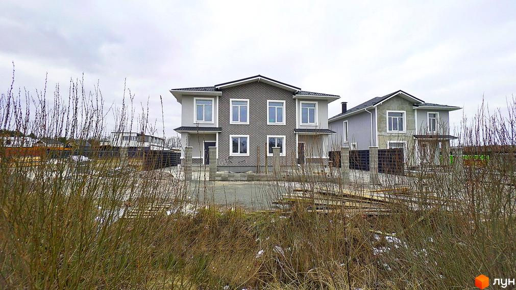 Новобудова на вулиці Василя Стуса. Зовнішній вигляд будинку з сірою цегляною вставкою та білими вікнами, навколо будмайданчик з будівельними матеріалами.