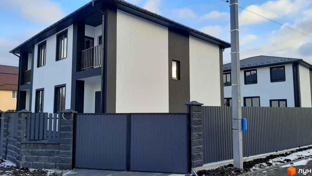 Зовнішній вигляд дуплексів Сонячний дім 3 з сірим парканом та воротами. Новобудова з білими та темними фасадами.
