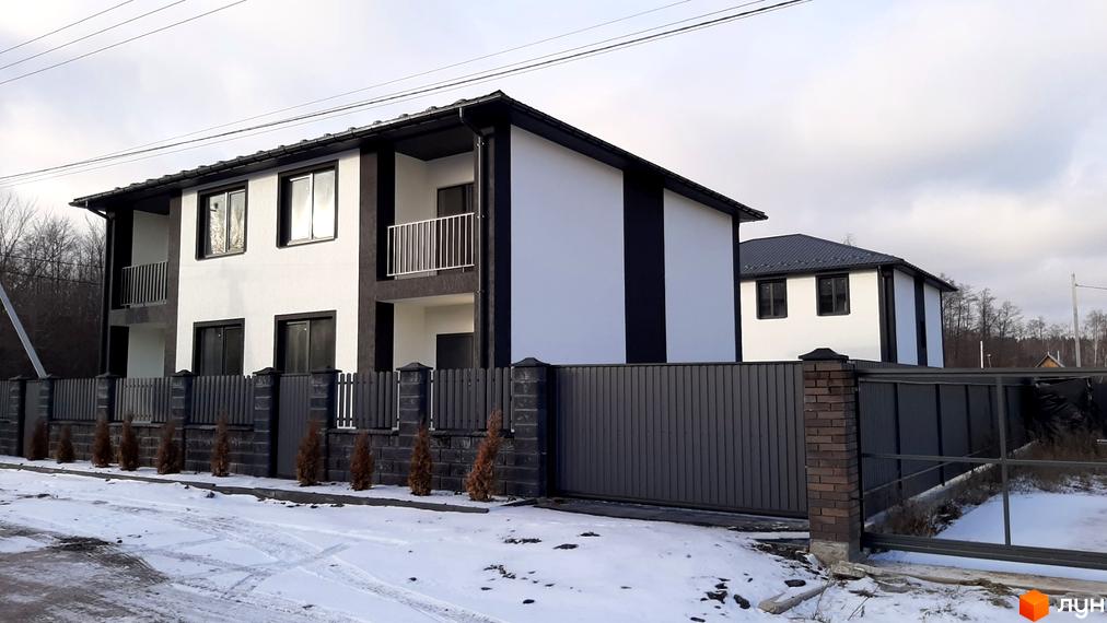 Двоповерхові дуплекси Сонячний дім 3 з біло-чорним фасадом та огородженою територією взимку. Сучасний житловий комплекс з парканом та воротами.