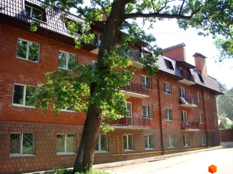 Житловий комплекс Green Park з червоної цегли, оточений зеленими деревами та прибудинковою територією.