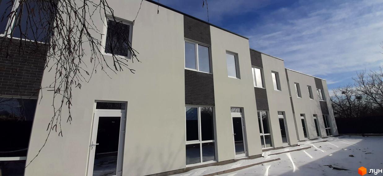 Котеджне містечко KM Holland Park: двоповерхові будівлі зі світлими фасадами та темними цегляними вставками. Навколо сніг та голі дерева.