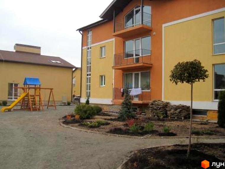 Зовнішній вигляд житлового комплексу Євроквартал з балконами та прибудинковою територією з дитячим майданчиком і зеленими насадженнями.