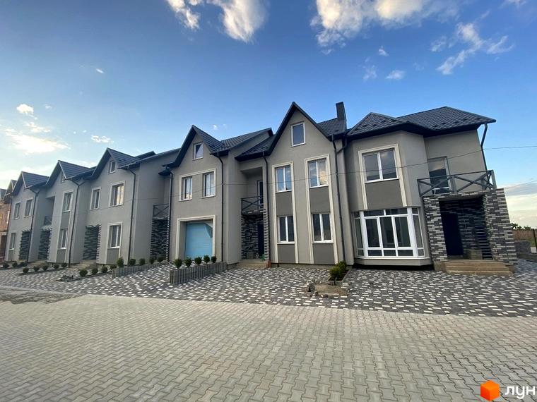 Таунхауси Hodillywood 2.0. Сірі двоповерхові будинки з темним дахом та бруківкою перед ними.