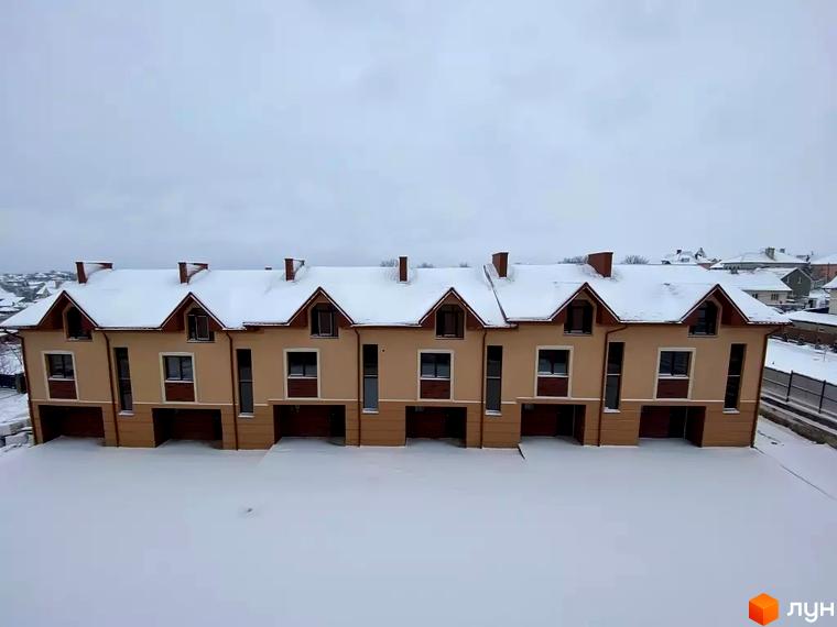 Таунхауси Hodillywood 4.0 взимку, з білим снігом на дахах та навколо будинків. Зовнішній вигляд будинків: двоповерхові, з коричневими дахами, світло-бежевими стінами та темними вікнами.