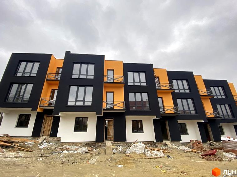 Таунхауси Hodillywood 6.0 - це двоповерхові будинки з чорними та помаранчевими фасадами, великими вікнами та балконами. Територія навколо будинків ще в процесі будівництва.