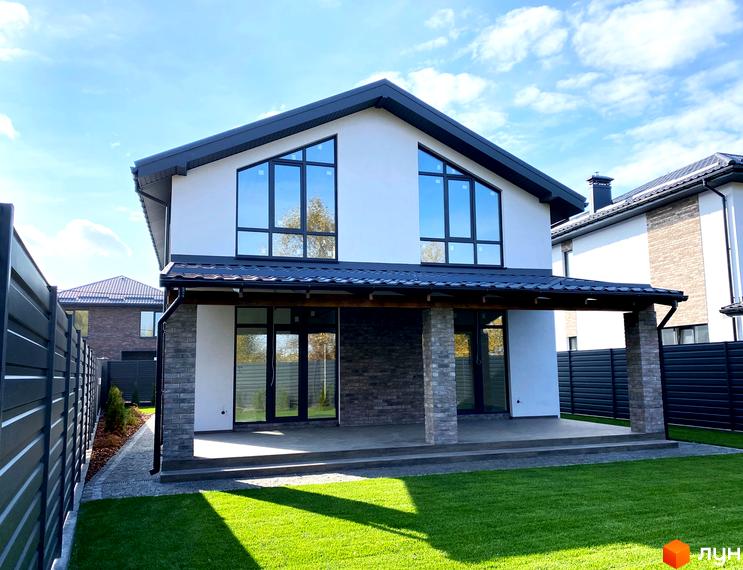 Двоповерховий будинок в Котеджному містечку Щастя з панорамними вікнами та просторою терасою. Зелена галявина та доглянута прибудинкова територія.