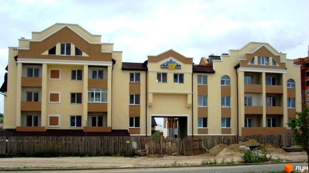 Житловий комплекс на вул. Богдана Хмельницького, 15-17 з фасадом жовто-коричневого кольору та прибудинковою територією.