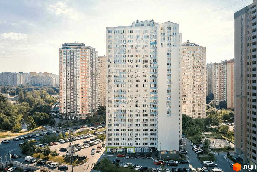 Високі будинки житлового комплексу з великою кількістю вікон, паркуванням та зеленими насадженнями навколо. Вулиця Урлівська, 23.