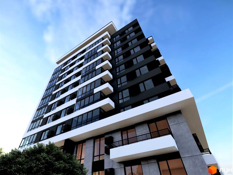 Новобудова ЖК ФАЙНЕ МІСТО з темним фасадом та білими балконами на фоні блакитного неба. Навколо новобудови зелені дерева.