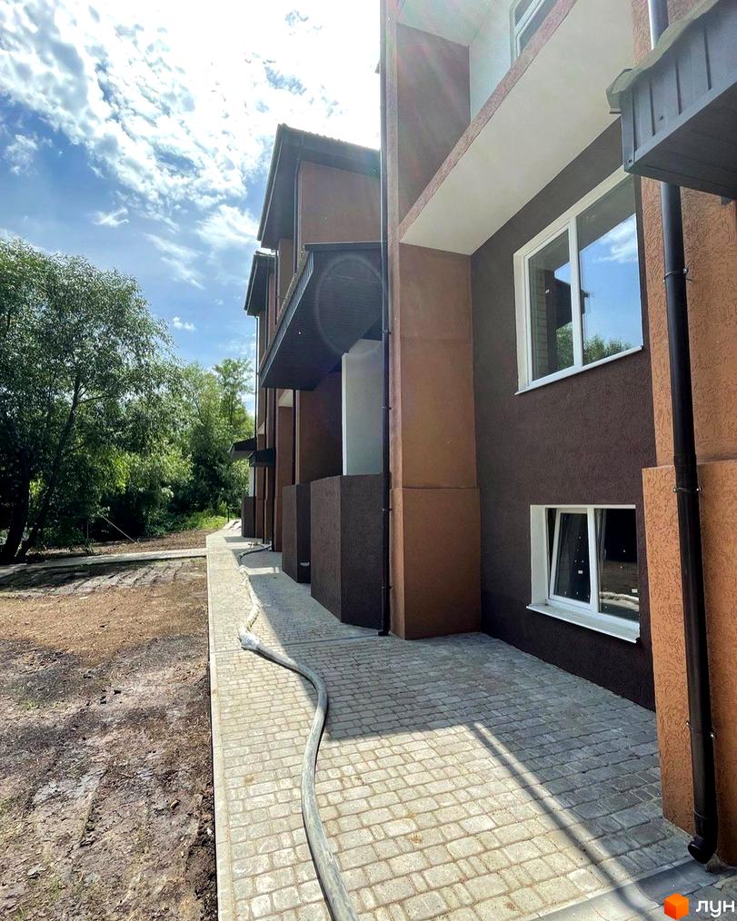 Зовнішній вигляд будинку Житлового комплексу Три шоколади. Вигляд на прибудинкову територію з тротуарною плиткою.