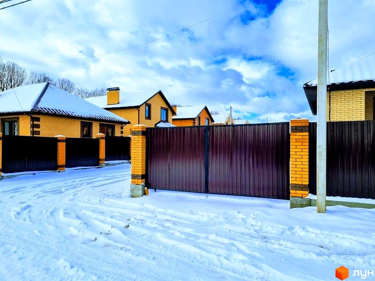 Котеджі Котеджного містечка Green city з жовтої цегли та коричневими дахами, вкриті снігом. Прибудинкова територія засніжена.