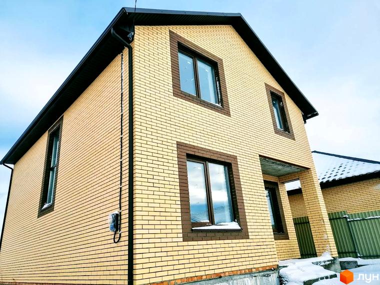 Котеджне містечко Green city. Двоповерховий будинок з жовтої цегли з коричневими віконними рамами та дахом, навколо засніжена територія.